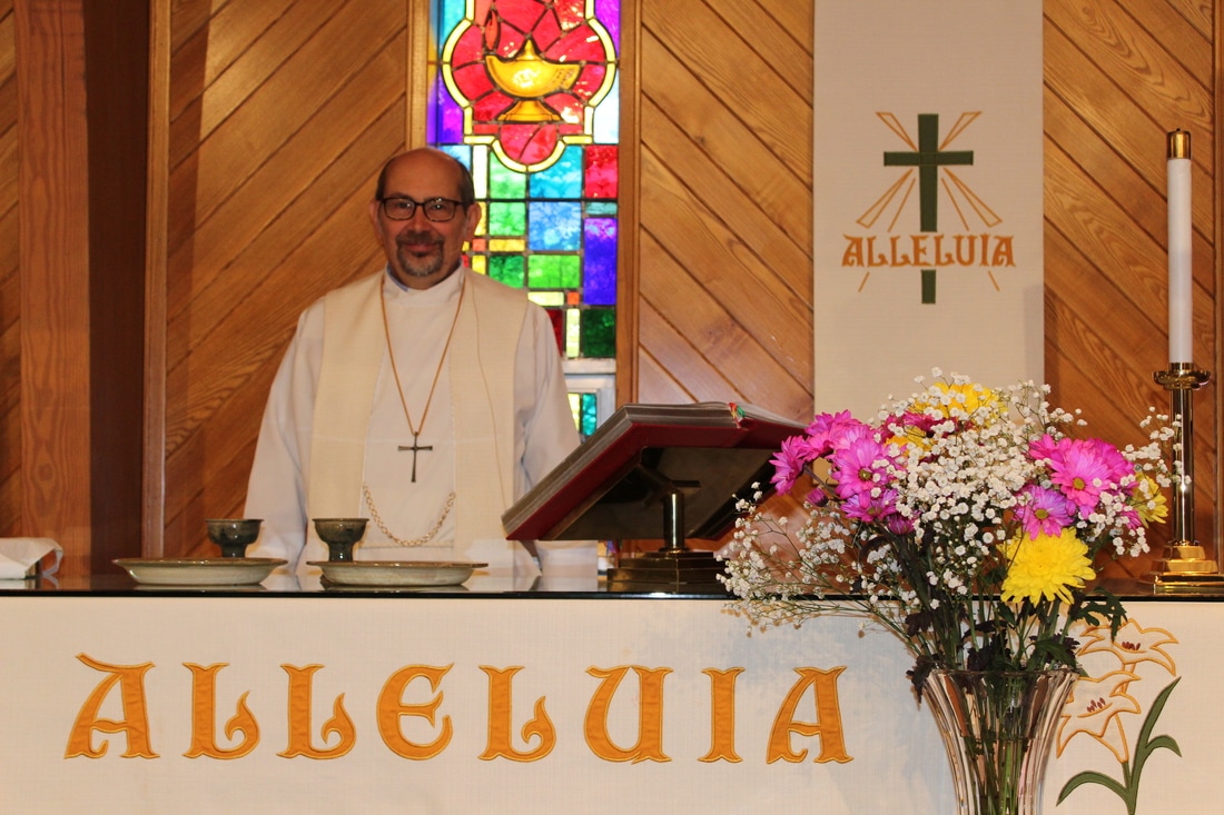 Pastor Rich Block behind altar and alleluia banner